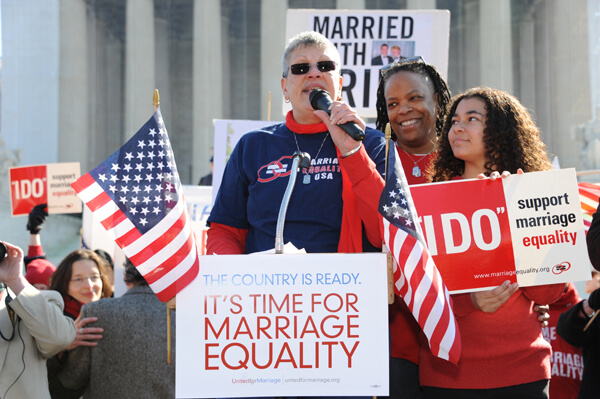 Cathy Marino-Thomas, co-president of the Marriage Equality USA board, with her wife Sheila and their daughter Jackie, speaking to a crowd outside the Supreme Court on March 26. | DONNA ACETO