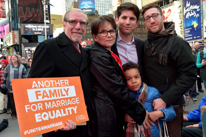 Gabriel Blau (center), executive director of the Family Equality Council, with his husband Dylan Stein, their son, and Blau’s stepfather George Hermann, and his mother RoseAnn Rosenfeld Hermann, at a Times Square rally on the eve of the Supreme Court arguments. | DONNA ACETO 