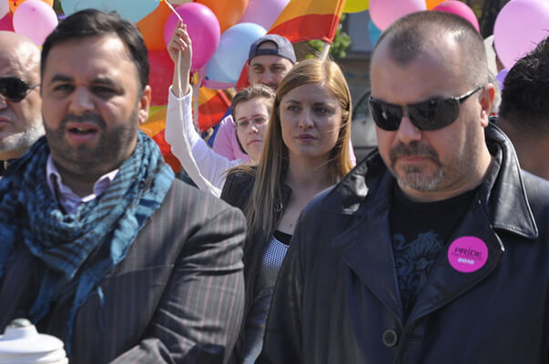Lemon sports a pink pride button as he stands with Radmillo (l.) at the gay pride celebration in Srdja Dragojevic’s “Parade.” | DELIRIUM FILMS
