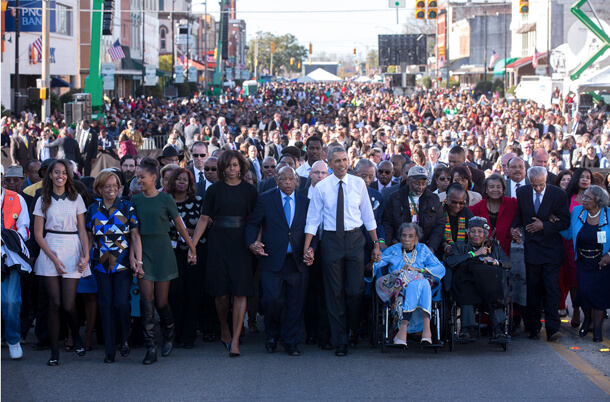President Barack Obama, with Michelle Obama, Congress member John Lewis, and (in wheelchair) Amelia Boynton Robinson, a 103-year-old activist who was knocked unconscious by a state trooper in the 1965 march. | PETE SOUZA/ THE WHITE HOUSE