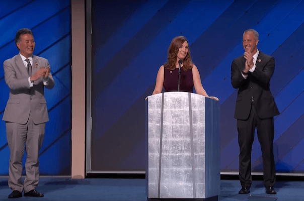 Sarah McBride, flanked by out gay US Representatives Mark Takano of California and Sean Patrick Maloney of New York, delivers remarks to the convention on Thursday evening. | DNC 