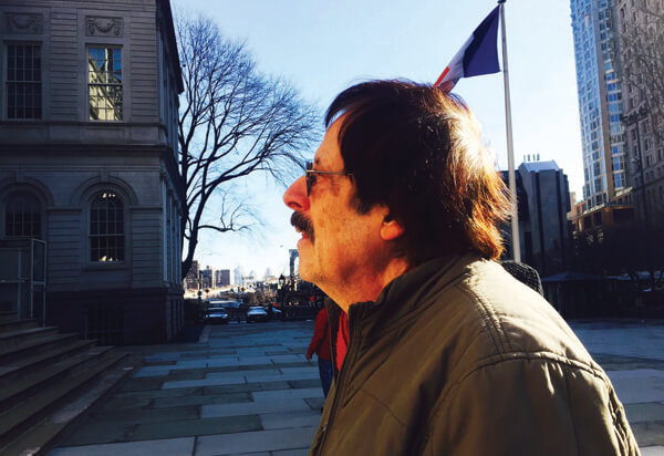 Ron Kolm, a co-founder of the collective the Unbearables, listens to other poets take their turn on the steps of City Hall. | PUMA PERL
