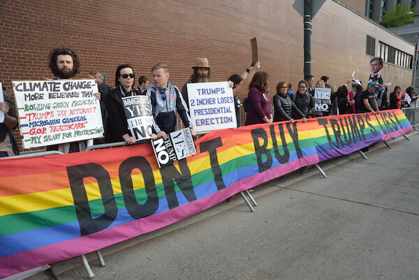 Rise and Resist and Gays Against Guns activists hoist a rainbow resistance banner created by the late Gilbert Baker, who died on March 31. | DONNA ACETO